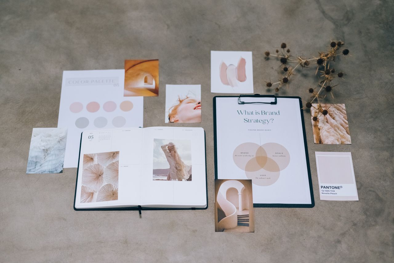 Une composition à plat d’éléments de branding, avec palettes de couleurs et documents de planification stratégique, posés sur une surface en béton.